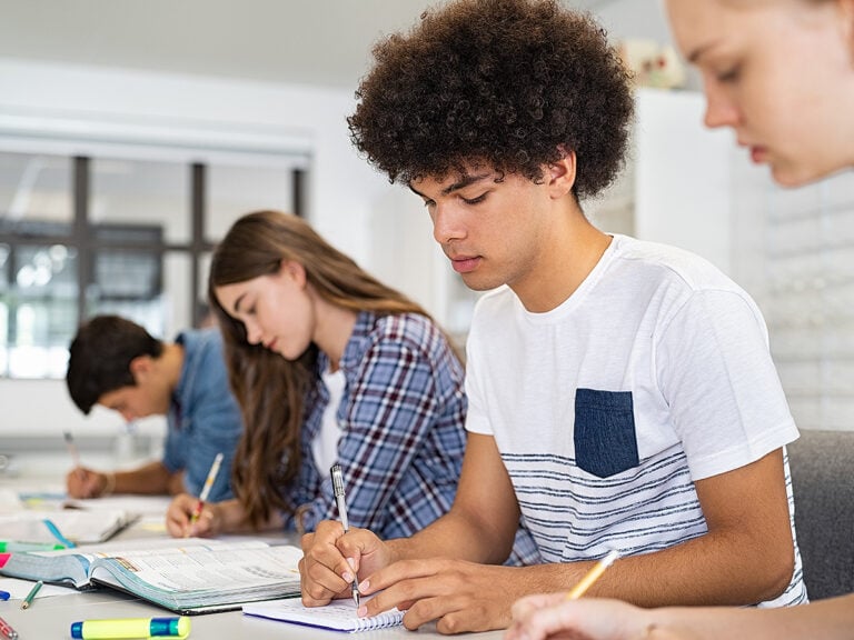 High school students focused while writing notes in school