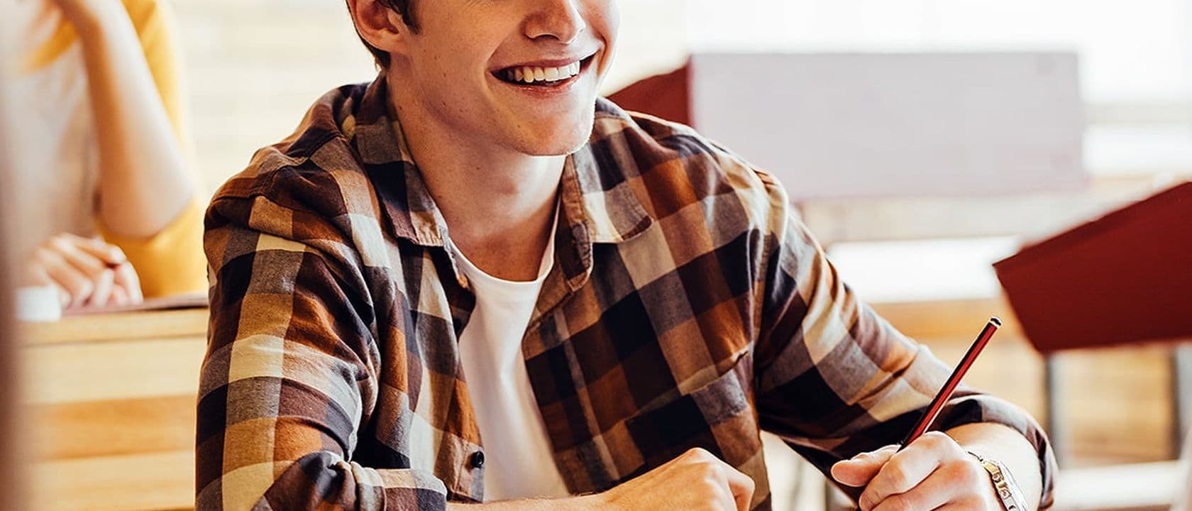 Teenage boy smiling during lecture in high school classroom