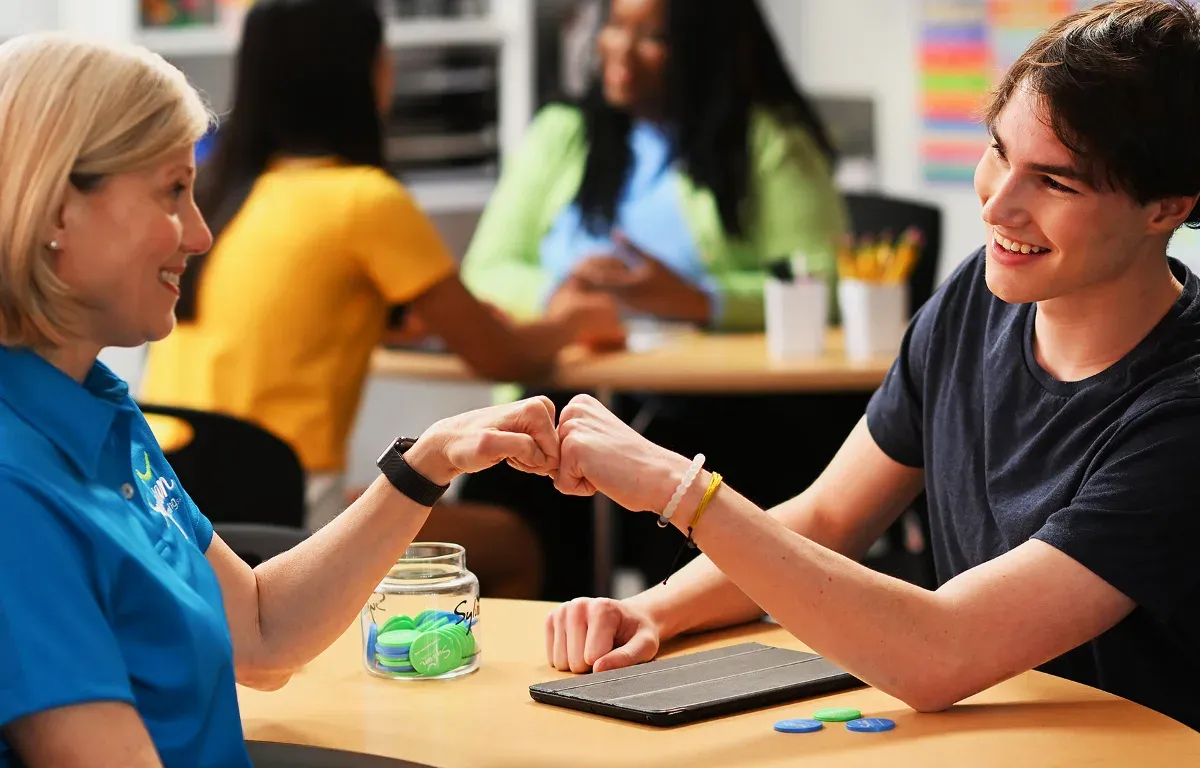 A Sylvan educator and student sharing a fist bump