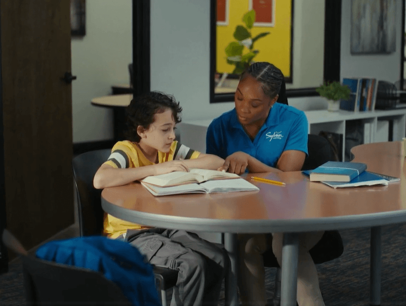 A tutor and student working together at a table