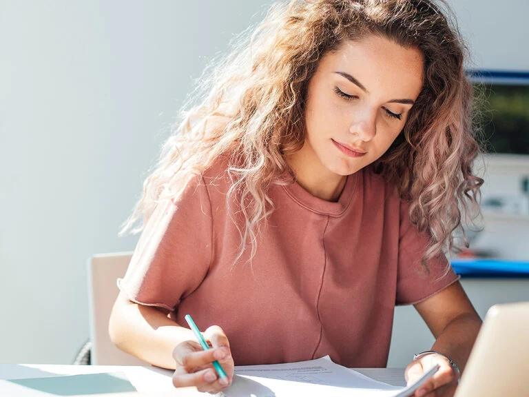 High school girl looking down writing notes