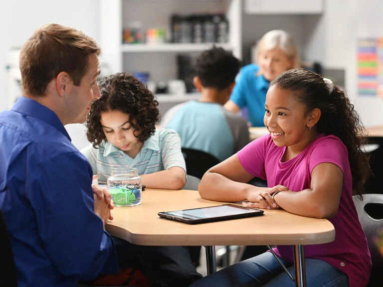 tutor and students at Sylvan Learning Center with tokens and ipad