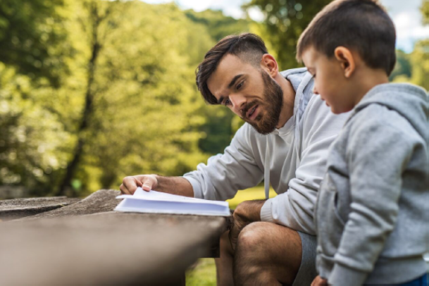 Teacher helping student at an outdoor table